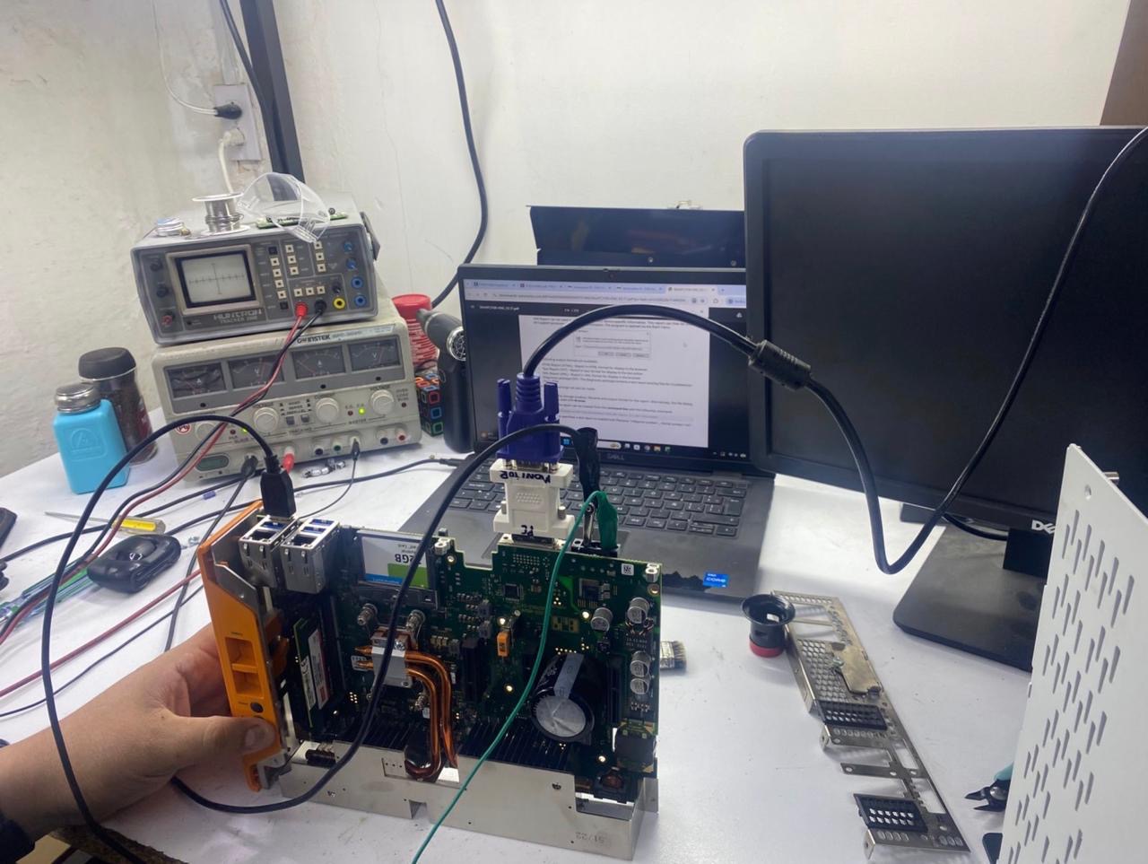 Equipo electrónico industrial abierto en el banco de diagnóstico de MABSER, conectado a instrumentos de medición